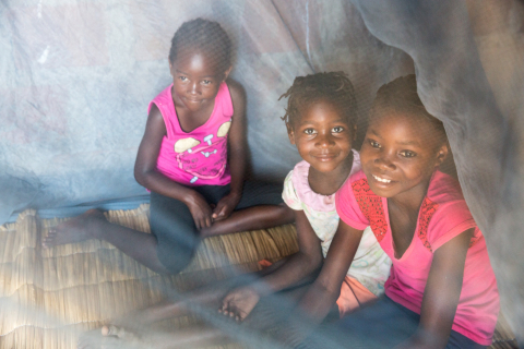 Children playing under mosquito net in RBM newsletter