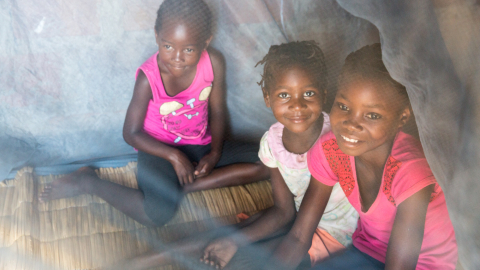 Children playing under mosquito net in RBM newsletter